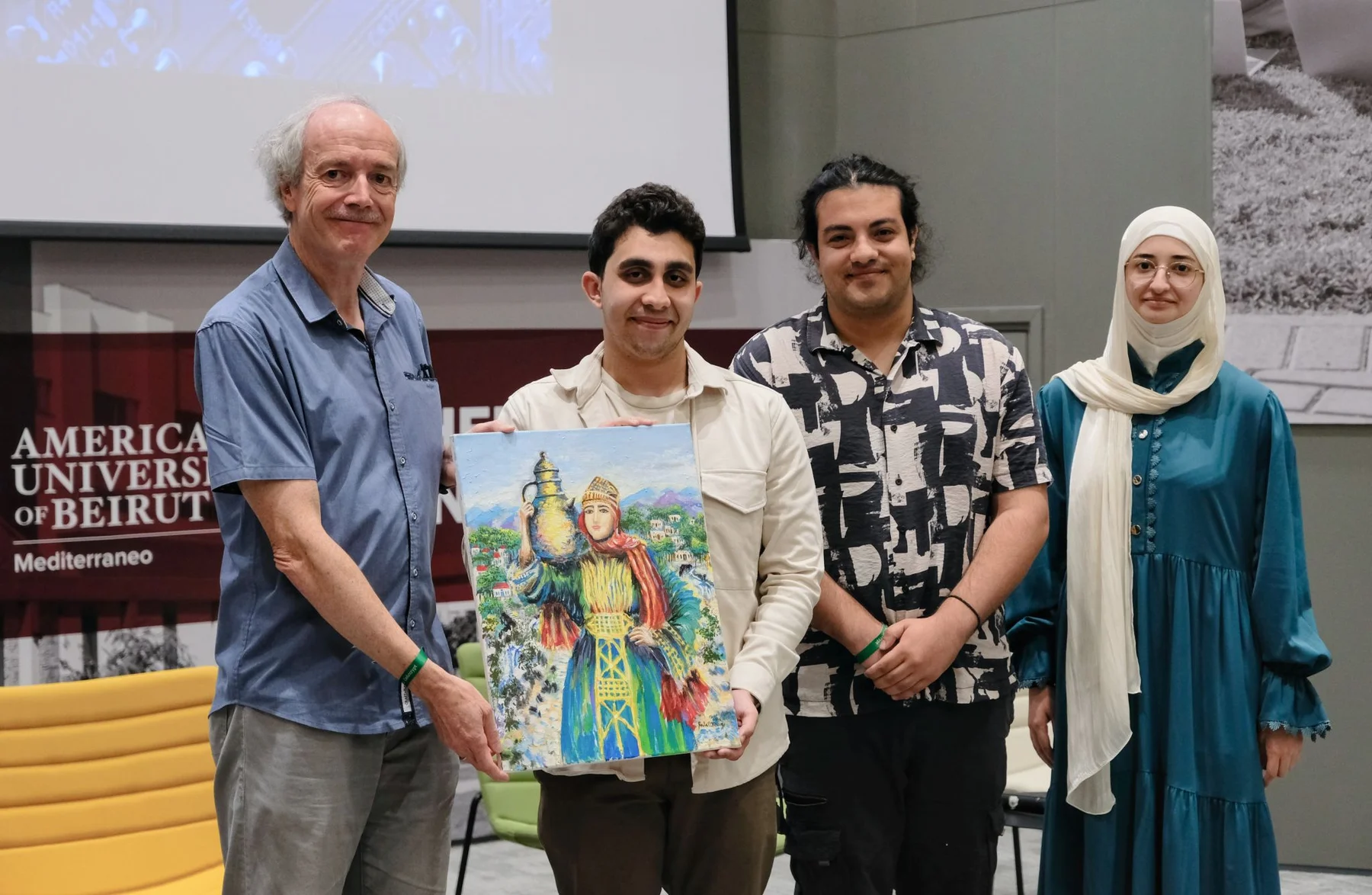 Three students presenting Bart Preneel with a painting of a woman carrying a water jar